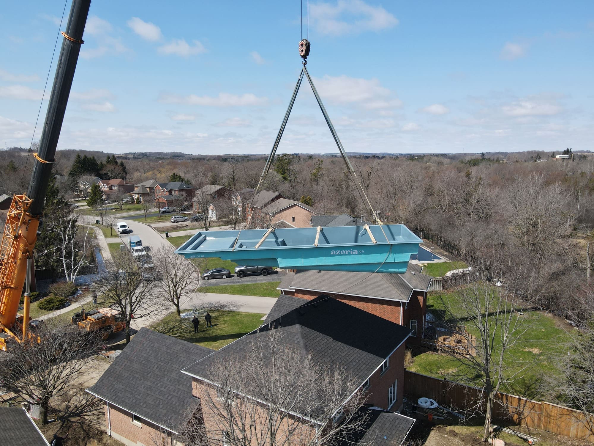 Fiberglass Pool In Kitchener, ON being craned into position over a house by Hipel Pools Fiberglass Pool In Kitchener, ON being craned into position over a house by Hipel Pools